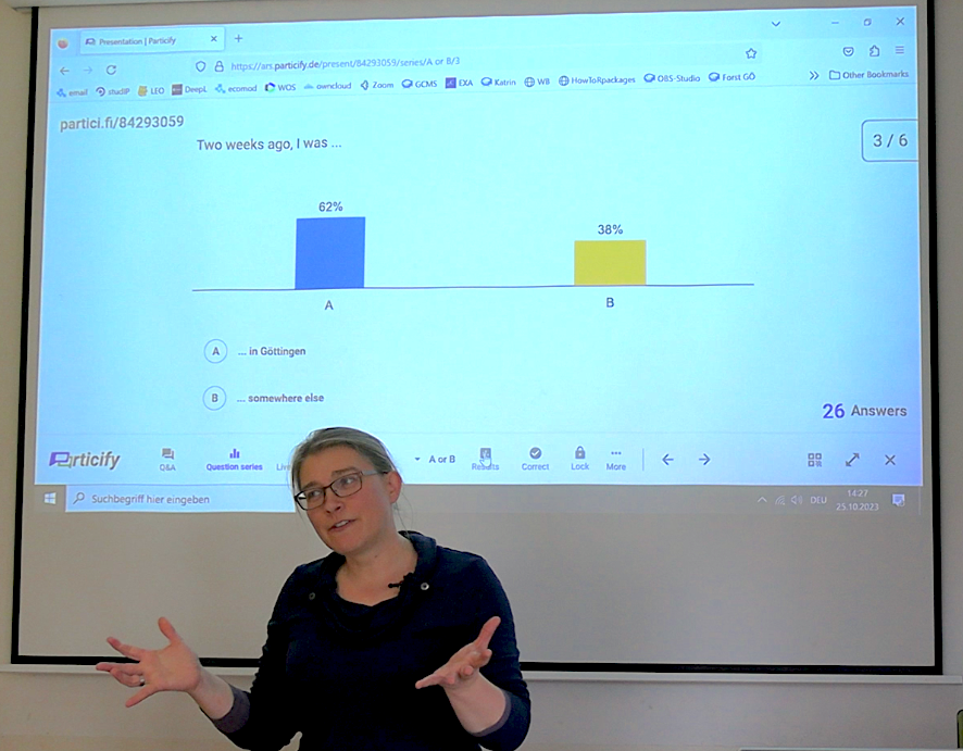 Besprechung_Antworten Katrin nutzt die Ergebnis-Ansicht von Particify in der Projektion, um auf die Antworten der Studierenden einzugehen. Sie hat 26 Antworten auf die Frage erhalten, wo sich die Personen vor zwei Wochen aufgehalten haben. 62% der Personen gaben „Göttingen“ als Antwort an.“