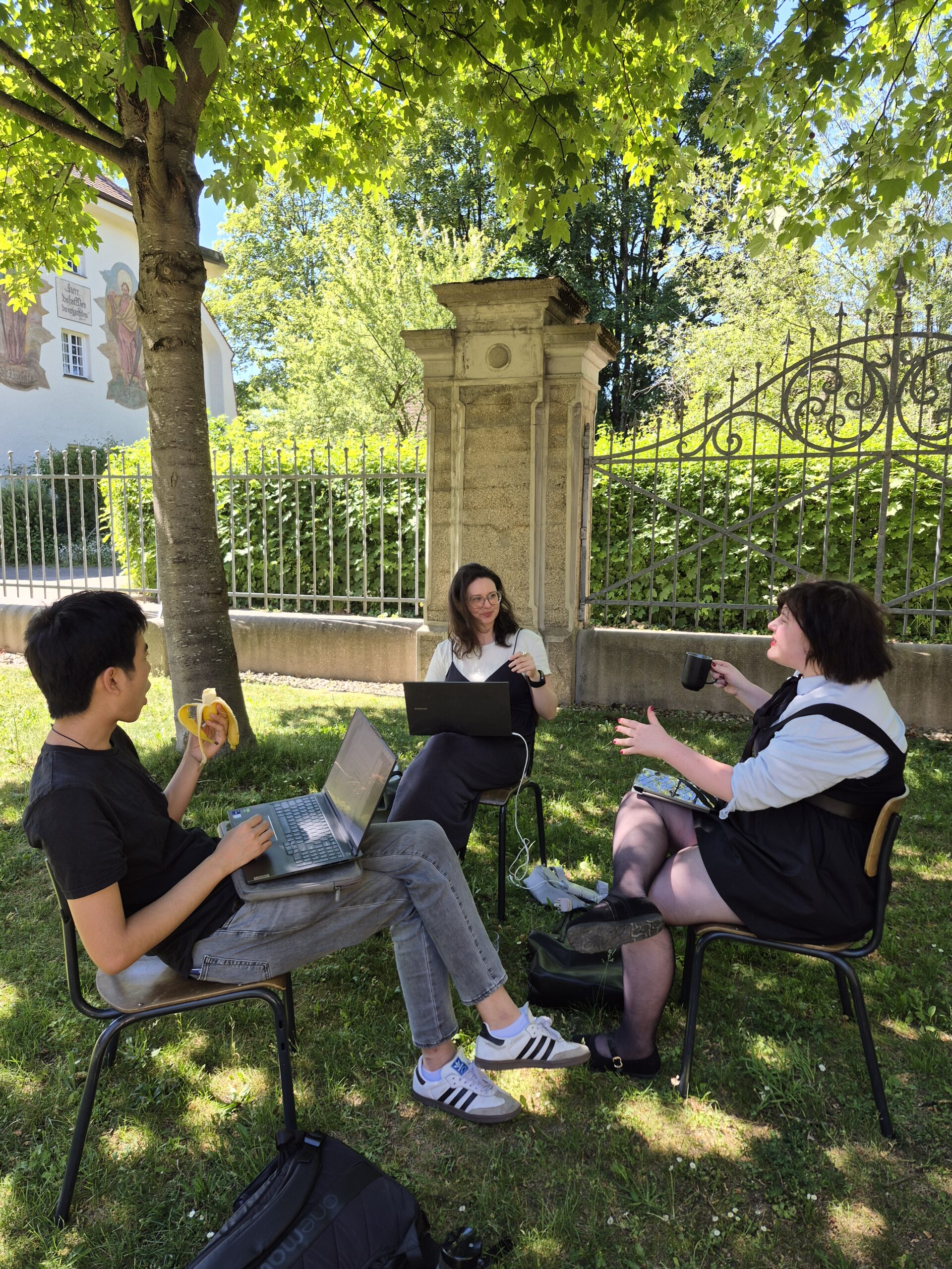 20260529_153112 Auf diesem Bild sieht man die DCMs des Thementracks AI beim Arbeiten im Garten der Hochschule München.